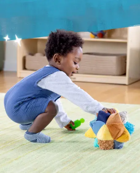 Baby rolling plush balls on a carpet