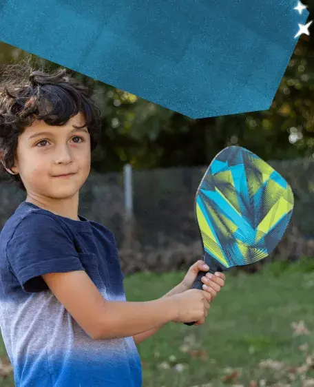 Small boy holding a pickleball paddle