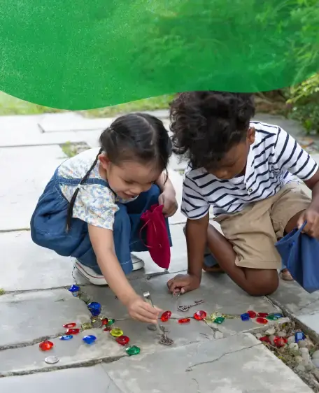 Girl playing with Transparent Tactile Shells on a light table