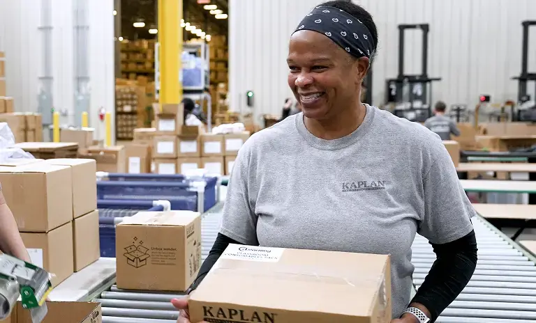Woman handling a cardboard box in a warehouse