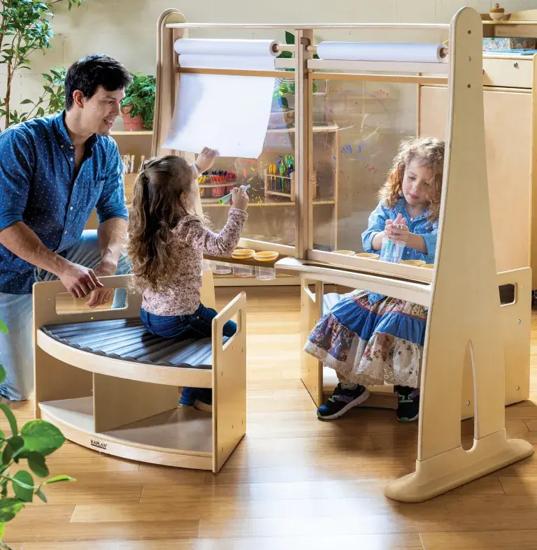 Teacher with young child using the Carolina Connections Easel